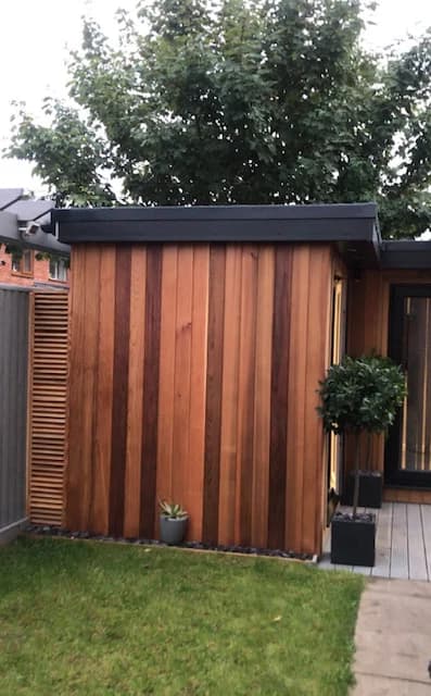 The completed timber-clad garden room beside the lawn